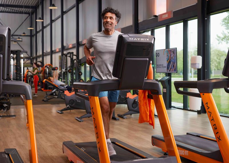 Older man running on the treadmill in a basic-fit gym